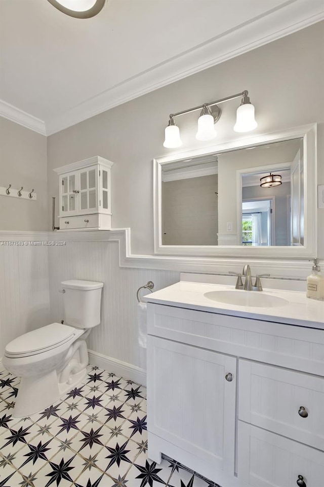 bathroom featuring vanity, ornamental molding, and toilet