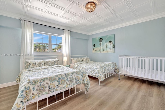 bedroom featuring crown molding and hardwood / wood-style floors