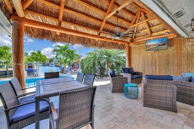 view of patio featuring a gazebo, an outdoor hangout area, a water view, and ceiling fan