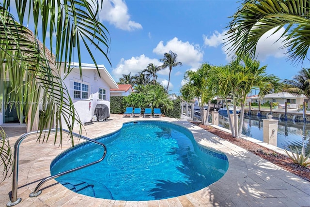 view of swimming pool featuring a patio area and a water view