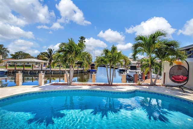 view of swimming pool with a water view and a boat dock