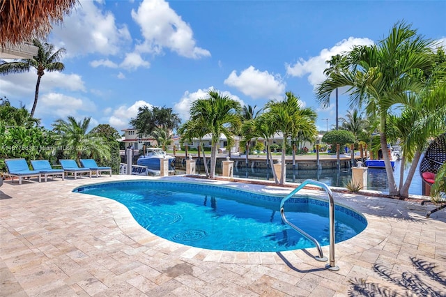 view of swimming pool featuring a patio area and a water view