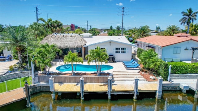 rear view of house with a water view and a patio area