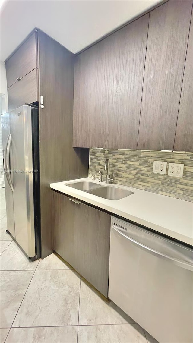 kitchen with sink, light tile patterned flooring, stainless steel appliances, and tasteful backsplash