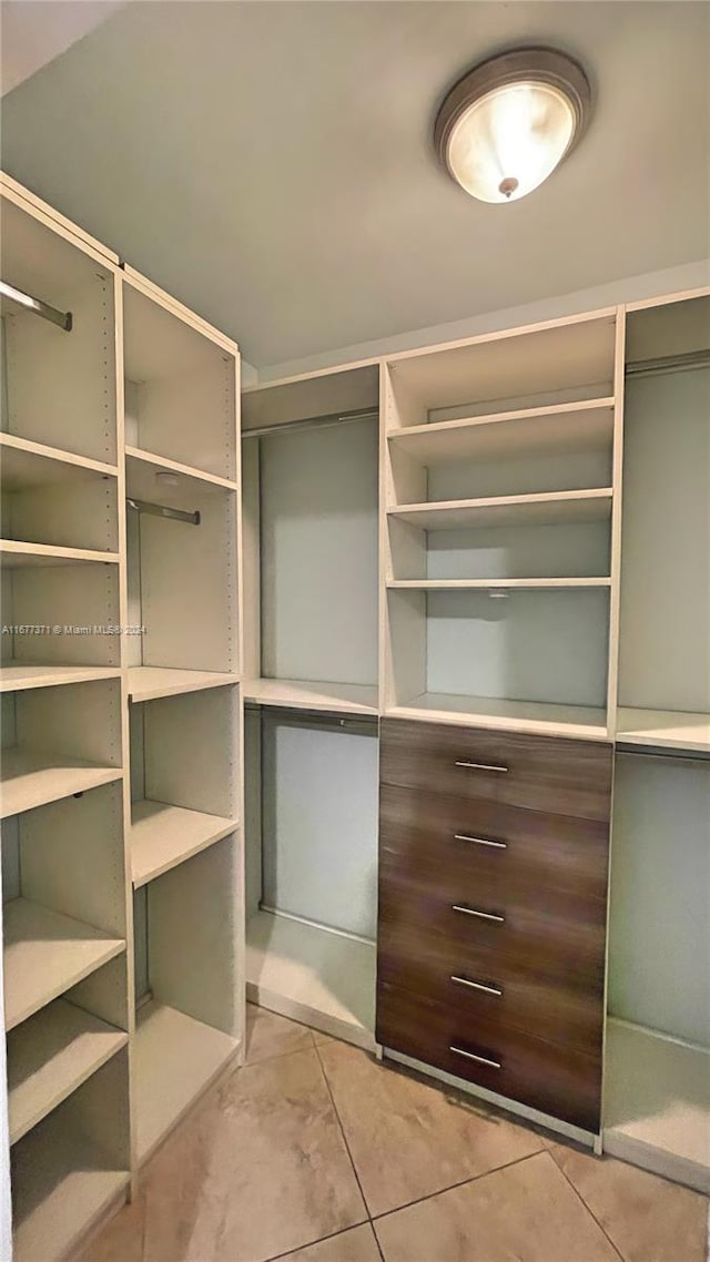 walk in closet with light tile patterned floors