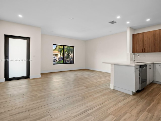 kitchen featuring dishwasher, light wood-type flooring, kitchen peninsula, and sink