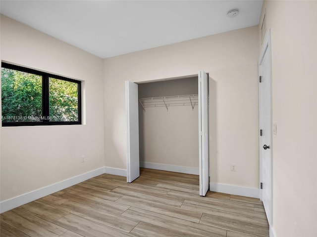 unfurnished bedroom with a closet and light hardwood / wood-style flooring