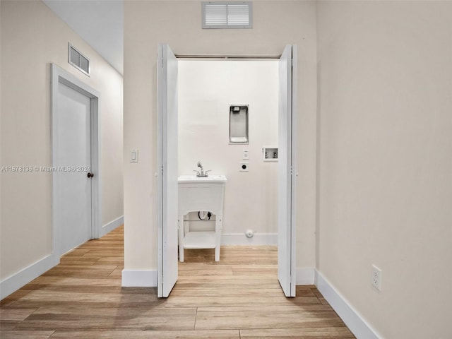 hallway with light hardwood / wood-style floors