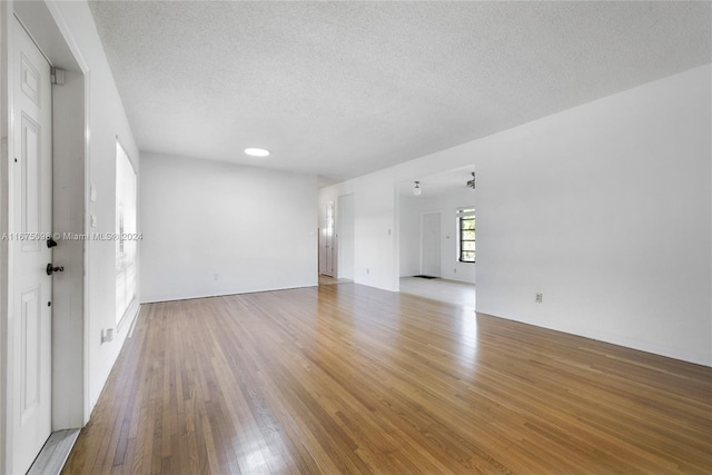 unfurnished room with a textured ceiling and hardwood / wood-style flooring