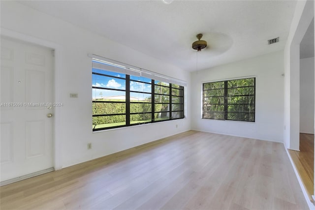 empty room with light hardwood / wood-style floors and a textured ceiling