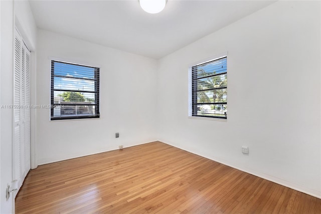 empty room with light hardwood / wood-style floors and a healthy amount of sunlight