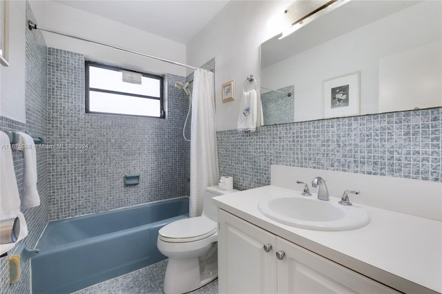 full bathroom with tile walls, vanity, shower / tub combo with curtain, and toilet