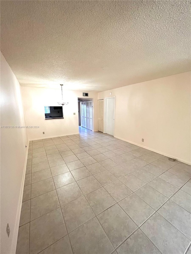 tiled spare room with a textured ceiling