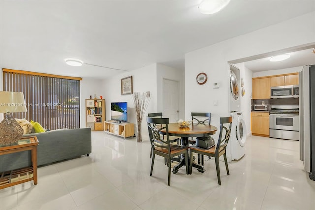 dining area with stacked washer and clothes dryer and light tile patterned floors