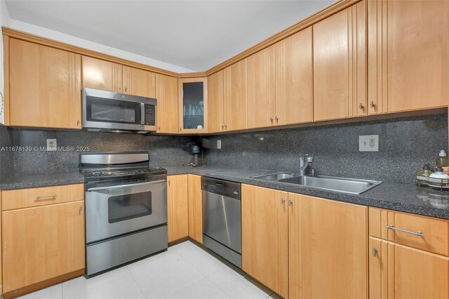 kitchen featuring backsplash, appliances with stainless steel finishes, and sink