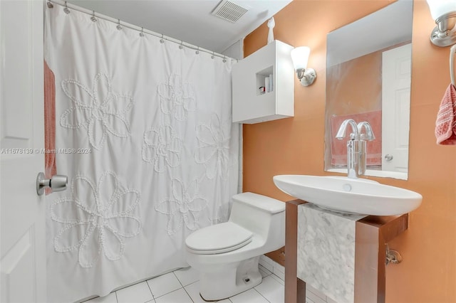 bathroom with toilet, curtained shower, sink, and tile patterned flooring