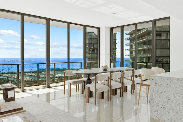 tiled dining area with a water view and floor to ceiling windows