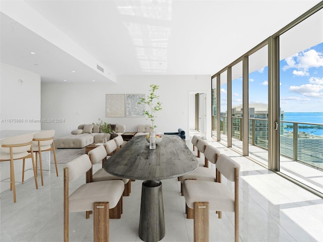 dining area featuring visible vents, floor to ceiling windows, a water view, and light tile patterned floors
