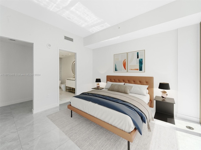 bedroom featuring ensuite bathroom and light tile patterned flooring