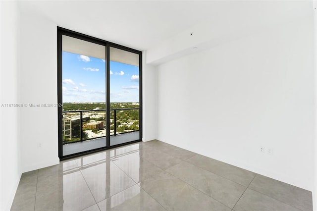 tiled empty room featuring expansive windows