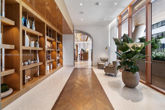 hall featuring arched walkways and recessed lighting