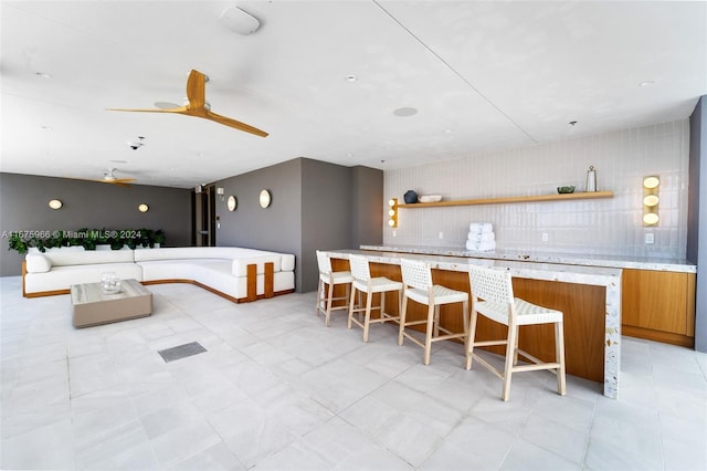 bar featuring backsplash and light tile patterned floors