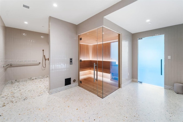 bathroom featuring recessed lighting, a tile shower, visible vents, and speckled floor