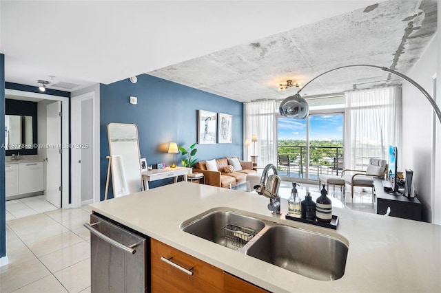 kitchen with light tile patterned flooring, stainless steel dishwasher, expansive windows, and sink