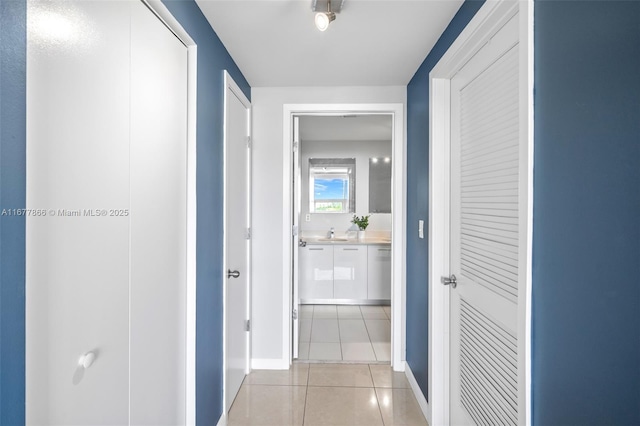 corridor featuring light tile patterned flooring and sink