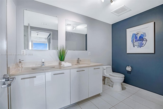 bathroom featuring vanity, tile patterned floors, and toilet