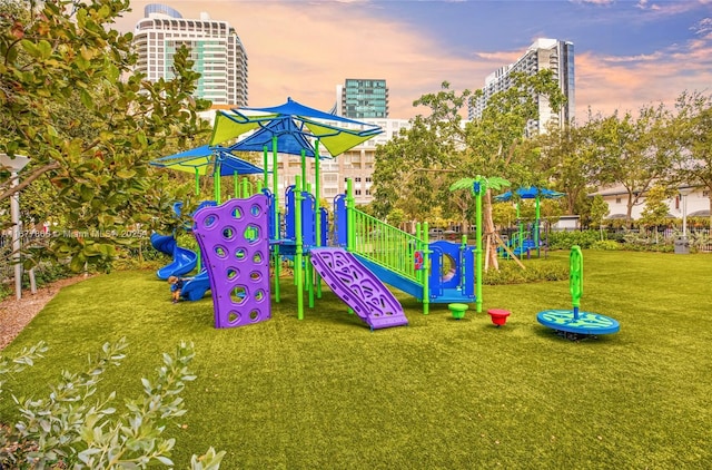 playground at dusk featuring a lawn