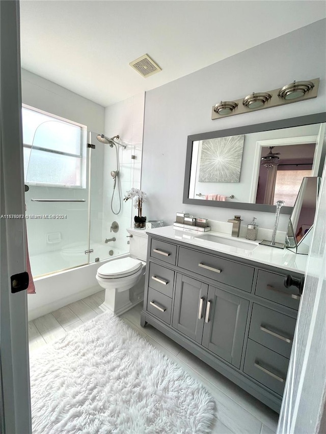 full bathroom with vanity, tub / shower combination, a healthy amount of sunlight, and toilet