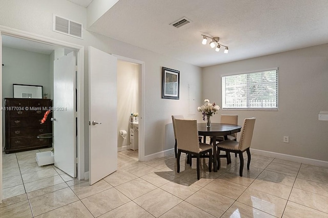 dining room featuring a textured ceiling and light tile patterned floors