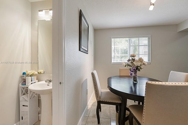 dining area featuring a textured ceiling and light tile patterned floors