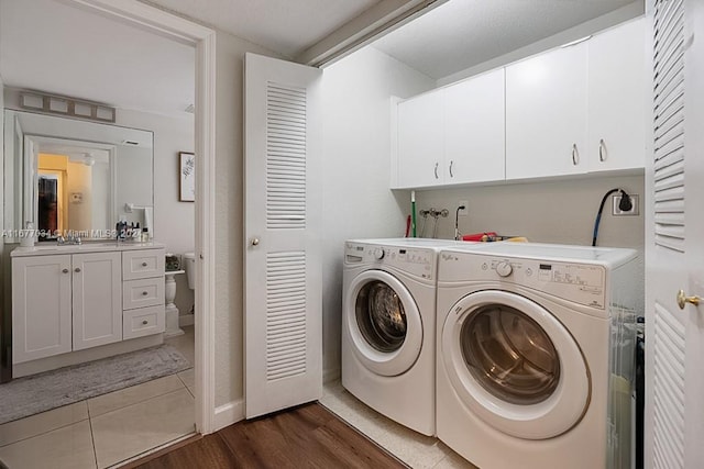 laundry area featuring sink, dark wood-type flooring, independent washer and dryer, and cabinets