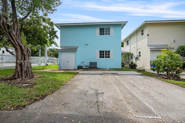 rear view of property featuring central AC unit