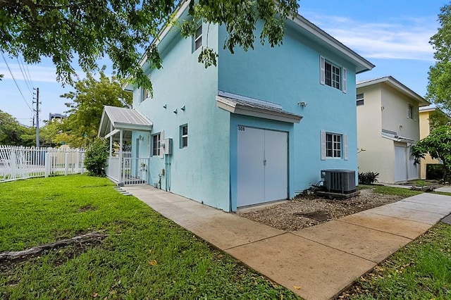 back of house featuring a lawn and central AC unit