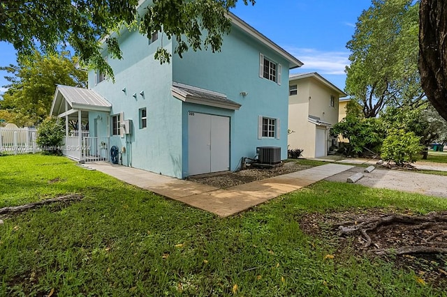 back of property featuring a yard and central AC unit