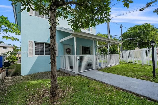 exterior space featuring covered porch and a lawn