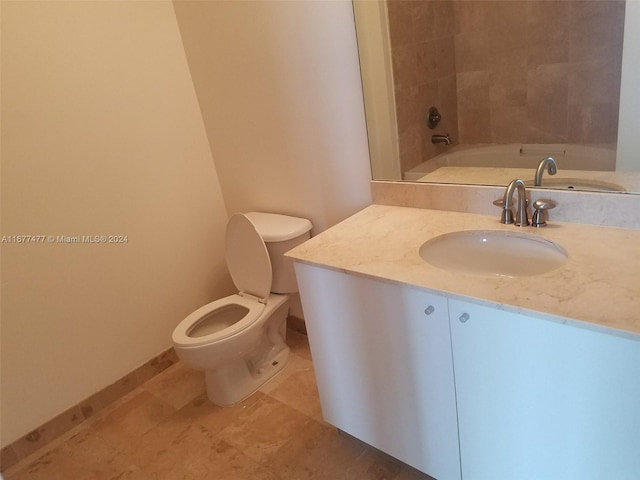 bathroom featuring vanity, toilet, and a tub to relax in