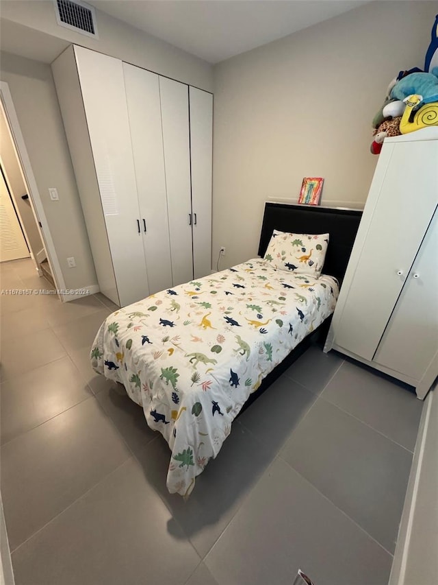 tiled bedroom with a closet