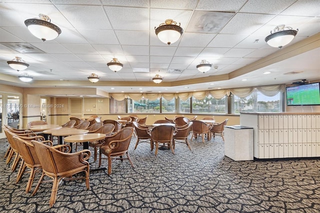 dining area with carpet and a paneled ceiling