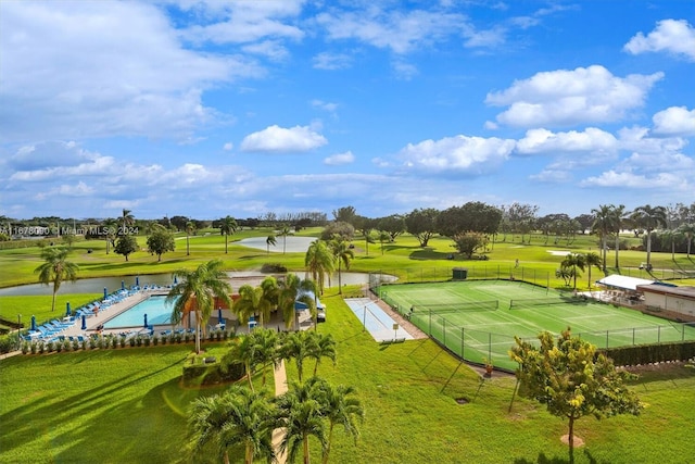 view of property's community featuring a water view, a lawn, and a swimming pool