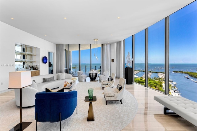 living room with light hardwood / wood-style floors, expansive windows, and a water view