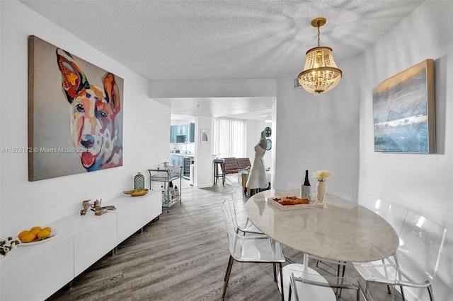 dining room featuring hardwood / wood-style flooring, beverage cooler, a textured ceiling, and a notable chandelier