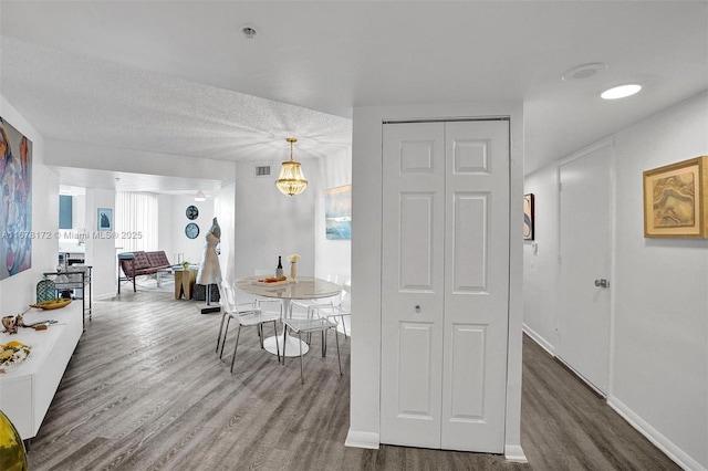 kitchen featuring pendant lighting, a textured ceiling, an inviting chandelier, and hardwood / wood-style floors