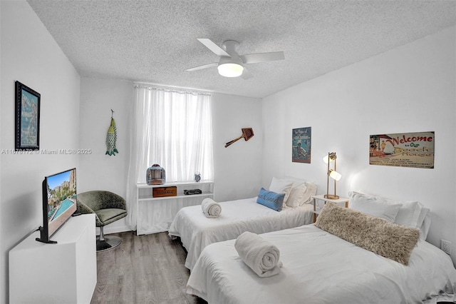 bedroom with hardwood / wood-style flooring, ceiling fan, and a textured ceiling