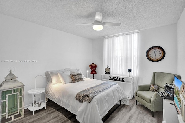 bedroom featuring multiple windows, wood-type flooring, a textured ceiling, and ceiling fan