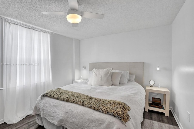 bedroom with ceiling fan, dark hardwood / wood-style flooring, and a textured ceiling