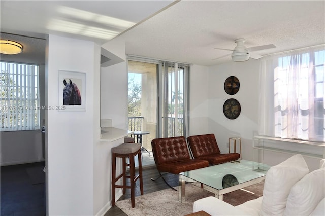 living room with hardwood / wood-style floors, ceiling fan, plenty of natural light, and a textured ceiling